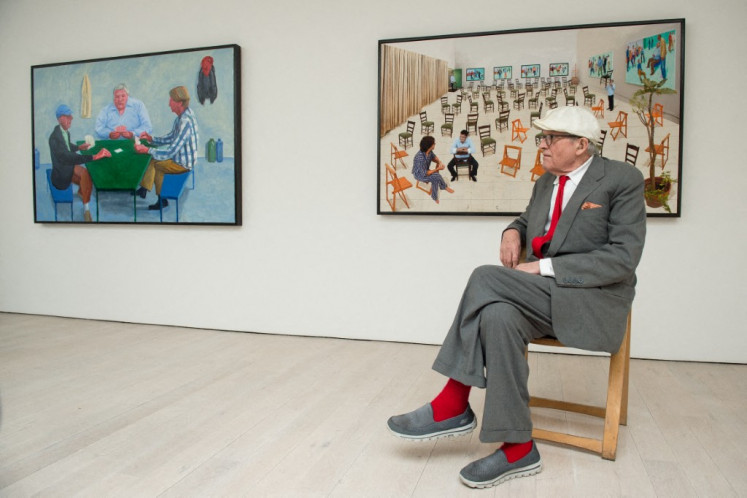 Artist David Hockney poses for photographers in front of his artworks &ldquo;Card Players #1&ldquo; (left) and &ldquo;The Chairs&ldquo; at a press preview of his new exhibition entitled &ldquo;Painting and Photography&ldquo; in central London, on May 14, 2015. 