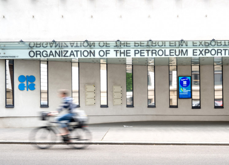A cyclist rides past the building headquarters of OPEC (Organization of The Petroleum Exporting Countries) in Vienna, Austria on May 28, 2025.