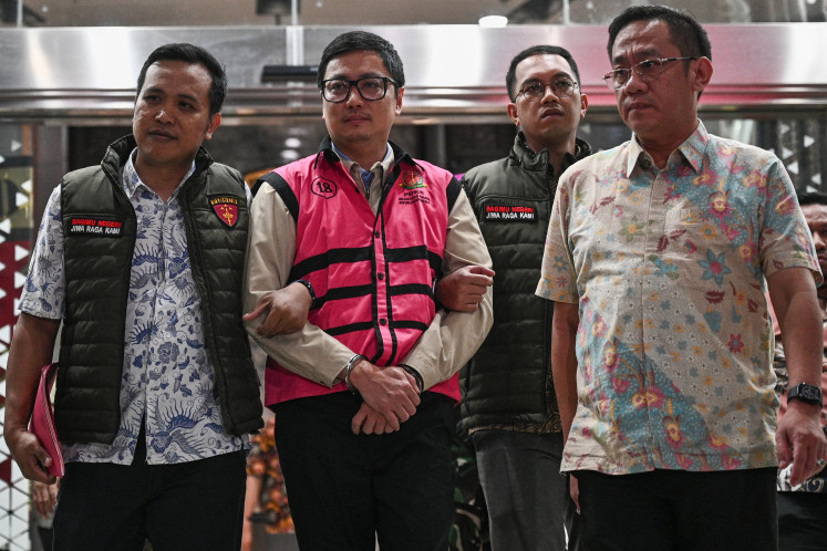 Corruption case suspect Andri Mulyono (second left), accused of involvement in the alleged misgovernance of the free nutritious meal program, walks toward a prisoner transport on Friday at the Attorney General&rsquo;s Office (AGO) in Jakarta.