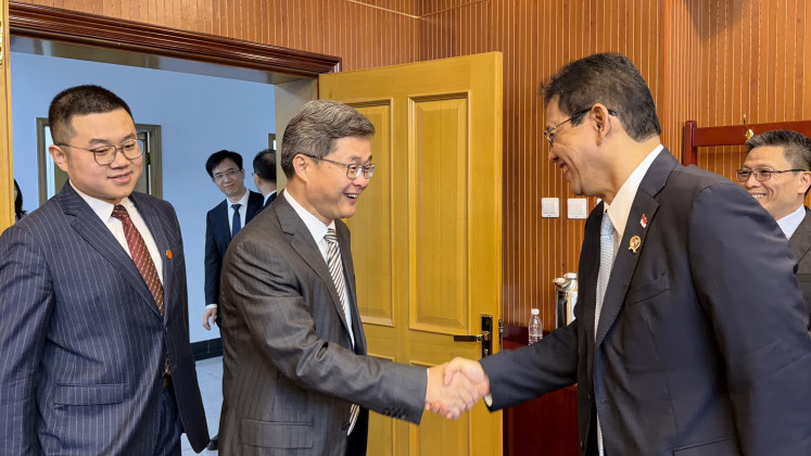 China's Finance Minister Lan Fo'an (left) and Indonesian Finance Minister Purbaya Yudhi Sadewa (right) shake hands ahead of a meeting on June 17, 2026, held in the former's office in Beijing.