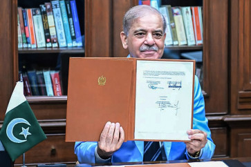 This handout photograph taken and released by Pakistan's Prime Minister's Office on June 18, 2026 shows Pakistan's Prime Minister Shehbaz Sharif holding the memorandum of understanding after signing it as a peace mediator to end the Middle East war, in Islamabad.  The United States and Iran have signed a deal to end the Middle East war, with a ceremony set for June 19 in Switzerland that will mark the start of a 60-day negotiation period. 