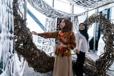 Two women explore a work of installation art at the Rainforest Youth Summit 2025 in Kuching, Sarawak state, Malaysia, in this undated photo.