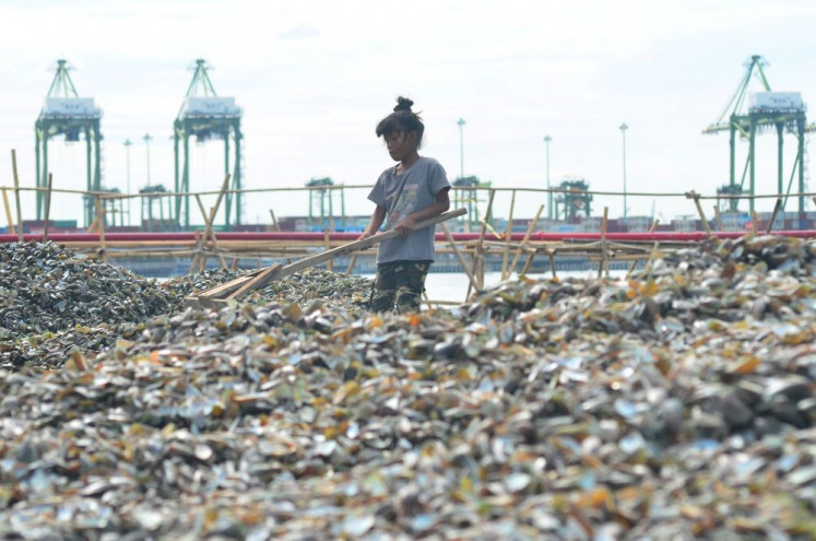 Waste no time: A teenage girl arranges piles of discarded shell waste on Oct. 25, 2025, in the Cilincing area of North Jakarta. Child labor remains a challenge facing the country&rsquo;s poverty alleviation drive.