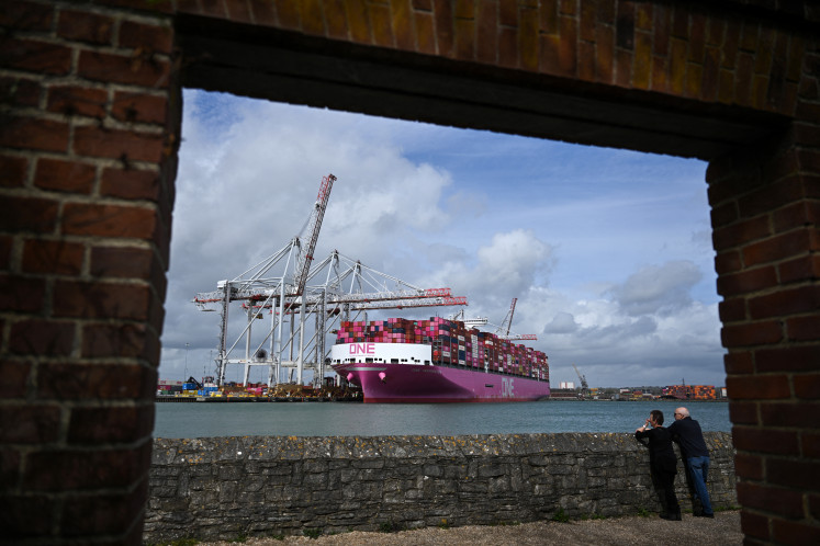People look towards the One Inspiration cargo ship, registered under the flag of Liberia, as it is loaded at the container terminal of Southampton Docks in Southampton on the south coast of England on April 16, 2026. June 23, 2026 marks 10 years since the UK voted for Brexit, upending the country's politics and triggering fraught negotiations that finally concluded when it left the European Union in January 2020.