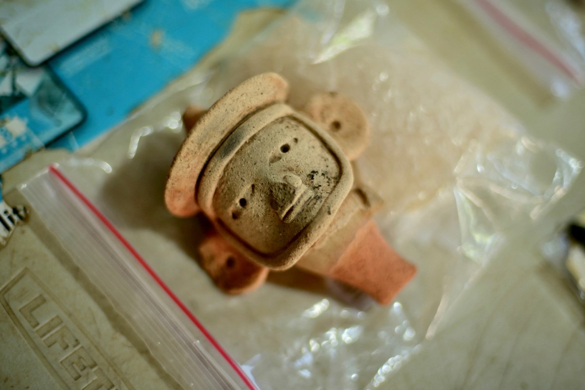 A view shows an anthropomorphic whistle face handled by archaeologists working at an archaeological site in Coatepec, Veracruz, Mexico, on June 18, 2026. Mexican archaeologists have discovered the remains of a structure and a sculpture bearing features similar to those of the Maya culture and other characteristics described as &ldquo;never before seen&rdquo; in the eastern state of Veracruz.