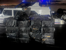 Boxes of illicit cigarettes are stacked in front of a customs patrol boat in an undisclosed location in Batam city, Riau Islands, in this undated picture released by Batam Customs and Excise Office. 11 out of 54 interdictions made in May consisted of cigarettes.  
