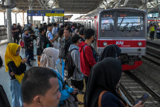 Commuter train passengers wait for the wagons to stop during the morning rush hour on November 8, 2024, at Manggarai Station in Jakarta.