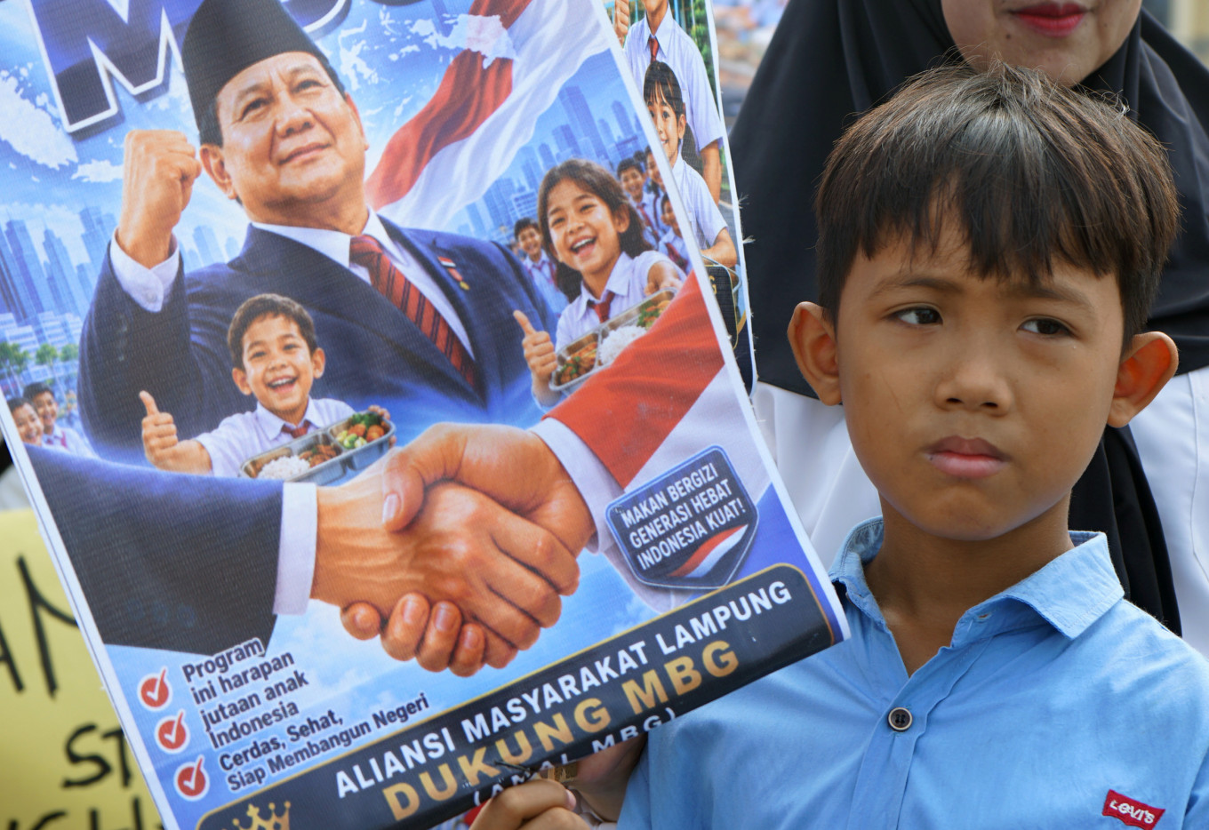 Protesters from the Lampung Community Alliance hold posters during a rally on June 22, 2026 at Adipura Monument in Bandar Lampung, Lampung. The group expressed support for the continuation of the free nutritious meal program, saying it benefits children, pregnant and breastfeeding women, and older adults. 
