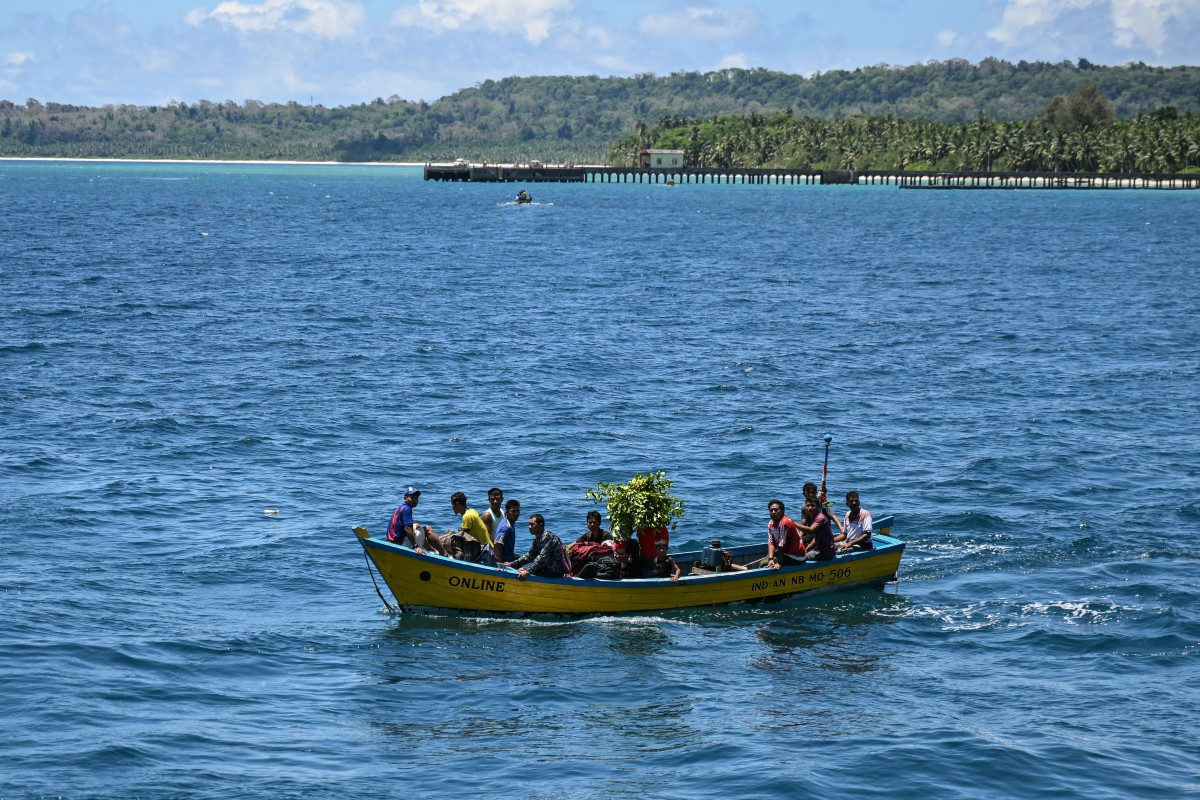Precarious arrival: Passengers on a boat on March 30, 2026, get ready to board the MV Kalighat vessel (not in picture) near Teressa in the waters of India's Andaman and Nicobar Islands.