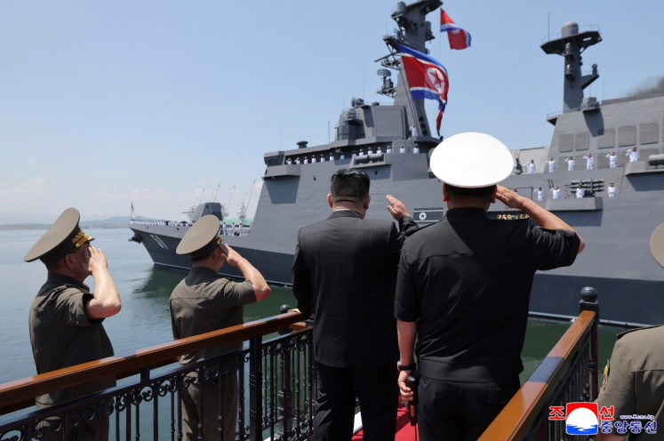 This picture taken on June 23, 2026 and released by North Korea's official Korean Central News Agency (KCNA) on June 24, 2026 shows North Korean leader Kim Jong Un (center) salutes the new-type multi-mission destroyer Choe Hyon following its commissioning ceremony at Nampo port in North Korea. 