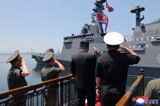 This picture taken on June 23, 2026 and released by North Korea's official Korean Central News Agency (KCNA) on June 24, 2026 shows North Korean leader Kim Jong Un (center) salutes the new-type multi-mission destroyer Choe Hyon following its commissioning ceremony at Nampo port in North Korea. 