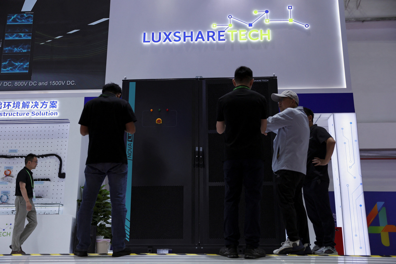 People check a display of a solid-state transformer at the Luxshare Tech booth during the China International Supply Chain Expo (CISCE) in Beijing on June 22, 2026.