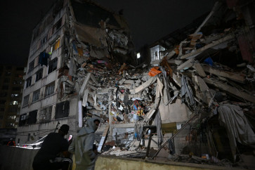 People look at a collapsed building in the Altamira neighbourhood following an earthquake in Caracas on June 24, 2026. Two earthquakes of magnitude 7.2 and 7.5 struck the same area of Venezuela on the evening of June 24, causing buildings to collapse, according to the United States Geological Survey (USGS) and AFP journalists. 