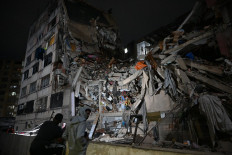 People look at a collapsed building in the Altamira neighbourhood following an earthquake in Caracas on June 24, 2026. Two earthquakes of magnitude 7.2 and 7.5 struck the same area of Venezuela on the evening of June 24, causing buildings to collapse, according to the United States Geological Survey (USGS) and AFP journalists. 