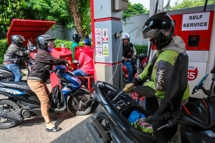Motorists queue on April 1 to refuel their bike at a gas station in South Jakarta.