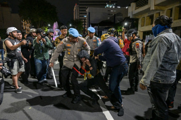 Police arrest a student following clashes during protest against a rise in non-subsidised fuel prices, inefficient government spending and military involvement in civilian affairs and the government's free school meals programme (MBG) in Surabaya on June 26, 2026. 