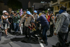 Police arrest a student following clashes during protest against a rise in non-subsidised fuel prices, inefficient government spending and military involvement in civilian affairs and the government's free school meals programme (MBG) in Surabaya on June 26, 2026. 