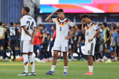 Germany's defender #24 Malick Thiaw, defender #05 Aleksandar Pavlovic, and defender #18 Nathaniel Brown react after losing the penalty shootout of the 2026 World Cup round of 32 football match between Germany and Paraguay at the Boston Stadium in Foxborough on June 29, 2026.