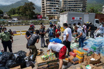 People receive donated food and drinks in Caraballeda, La Guaira state, Venezuela, on June 27, 2026, following earthquakes.