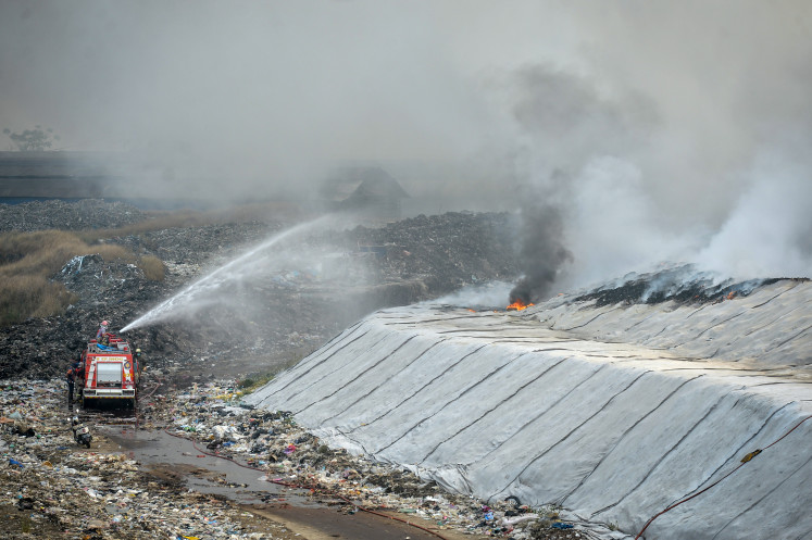Firefighters work to extinguish a blaze at the Jatiwaringin landfill in Tangerang regency, Banten, on June 30, 2026.
