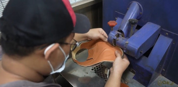 A shoemaker works on a pair of shoes at Pabrik Sepatu Bandung Cibaduyut 1920 in Bandung, West Java.