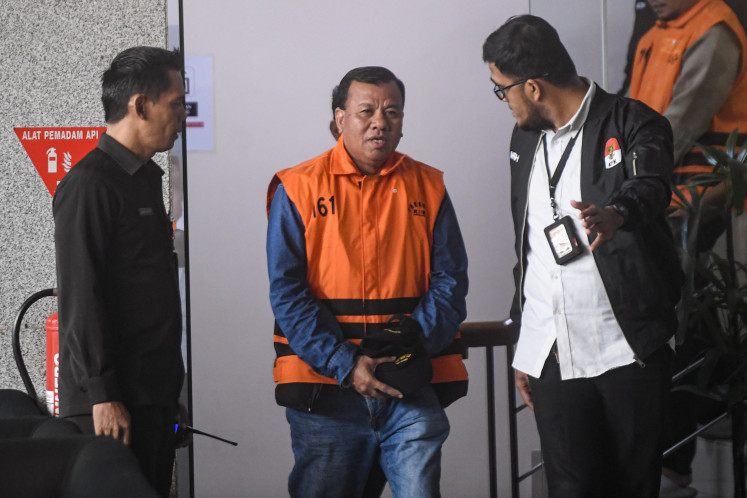 Kuantan Singingi Regent Suhardiman Amby (center) walks after questioning at the Corruption Eradication Commission (KPK) headquarters in South Jakarta on July 1, 2026. The KPK named Suhardiman and Kuantan Singingi Secretary Zulkarnain as suspects in an alleged bribery case.