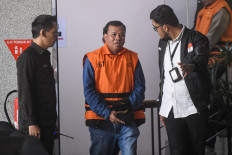 Kuantan Singingi Regent Suhardiman Amby (center) walks after questioning at the Corruption Eradication Commission (KPK) headquarters in South Jakarta on July 1, 2026. The KPK named Suhardiman and Kuantan Singingi Secretary Zulkarnain as suspects in an alleged bribery case.