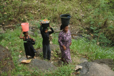 Residents carry buckets of water collected from a natural spring on June 20 in Gunung Putri village, Situbondo regency, East Java. Villagers say they have struggled to access clean water for drinking and daily needs over the past month, forcing them to walk about one kilometer to the spring.