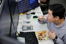 Lee Seok Jin, manager of Financial Markets Division and FX Platform Business Dept, eats dinner while working a late-night shift in preparation for the launch of South Korea's 24-hour won-dollar trading market from July 6, at Hana Bank's dealing room in Seoul, South Korea, on June 16, 2026.