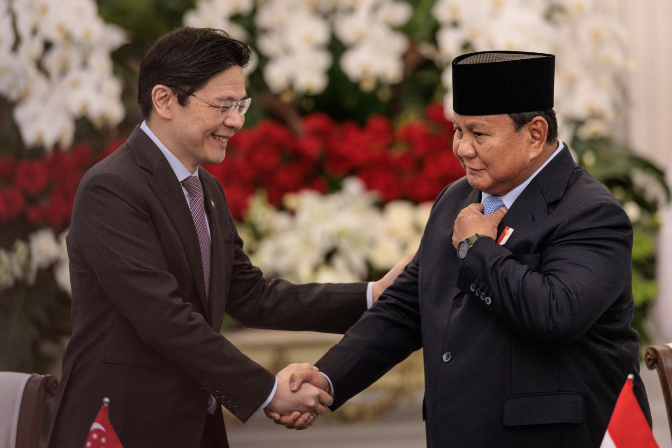 Singapore's Prime Minister Lawrence Wong (left) and President Prabowo Subianto shake hands on Monday during a joint press conference at the Merdeka Palace in Jakarta. 