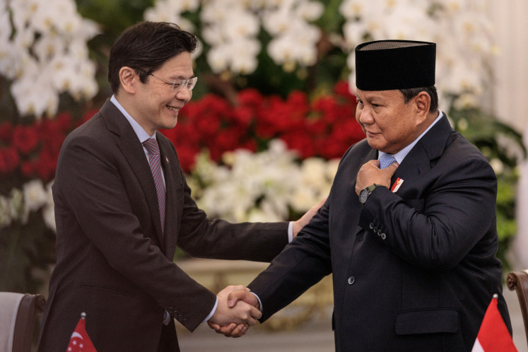 Singapore's Prime Minister Lawrence Wong (left) and President Prabowo Subianto shake hands on Monday during a joint press conference at the Merdeka Palace in Jakarta. 