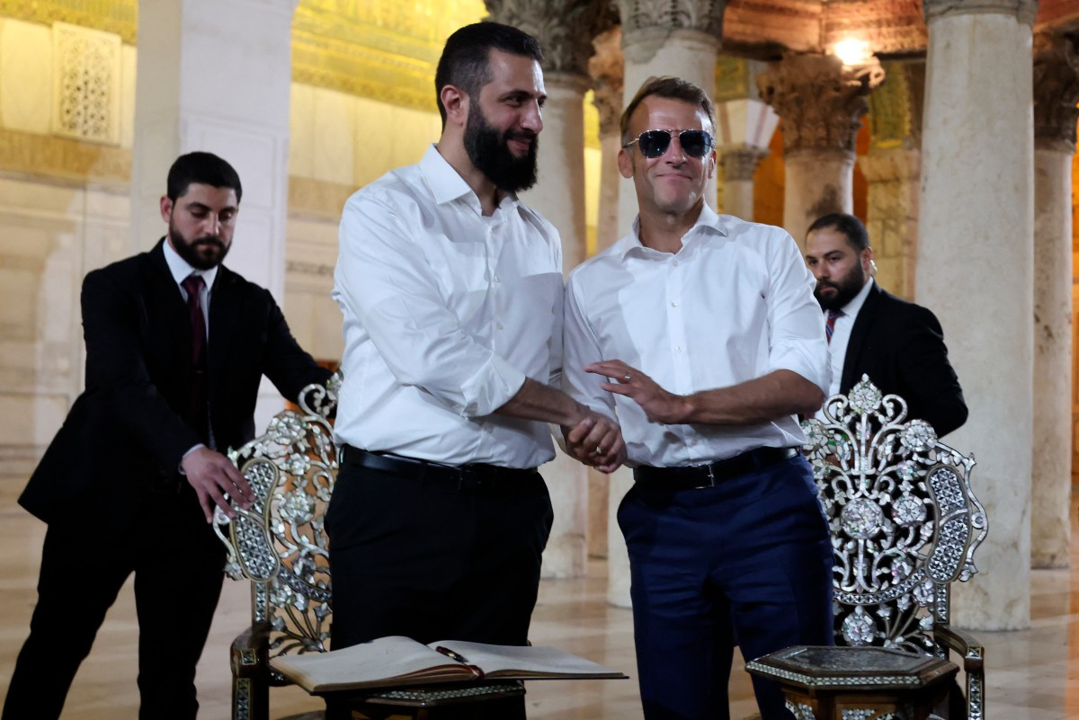 France's President Emmanuel Macron (right) shakes hands with Syrian President Ahmed Al-Charaa during a visit to the Umayyad Mosque in Damascus, on July 6, 2026. 