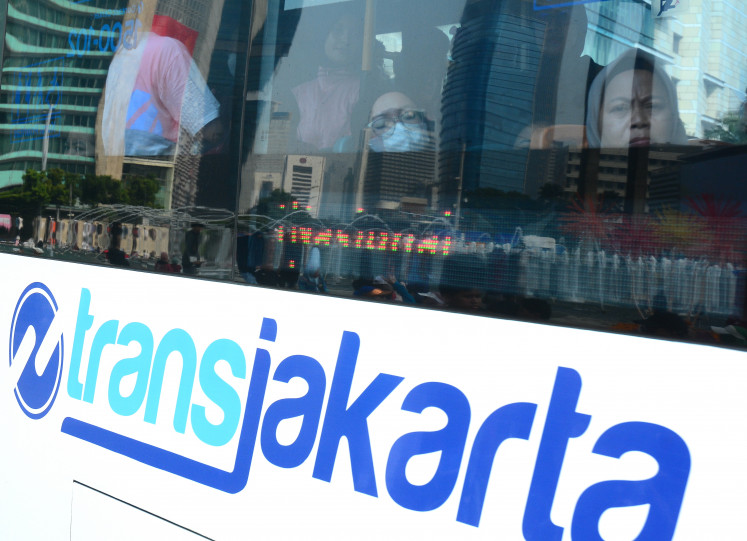 Passengers ride a Transjakarta bus traveling through the Hotel Indonesia traffic circle area in Central Jakarta on June 21, 2026.