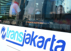 Passengers ride a Transjakarta bus traveling through the Hotel Indonesia traffic circle area in Central Jakarta on June 21, 2026.