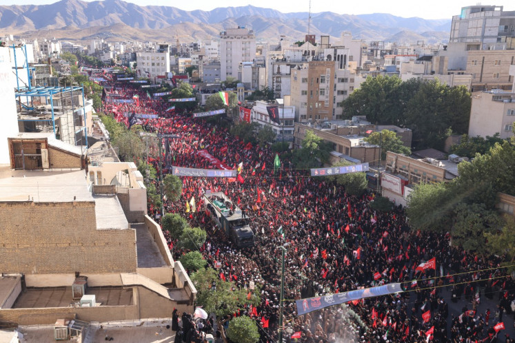 Crowds of mourners surround the convoy carrying the coffins of Iran's slain supreme leader Ali Khamenei and members of his family during a funeral procession, before he is buried at the Shrine of Imam Reza, Iran's most revered place of worship, in Mashhad on July 9, 2026. Iranians loyal to the Islamic republic massed on July 9 for the burial of slain supreme leader Ali Khamenei in his hometown of Mashhad.