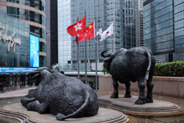 Bull statues are pictured near screens showing the Hang Seng stock index and stock prices outside Exchange Square, in Hong Kong, China, on Feb. 3, 2026.
