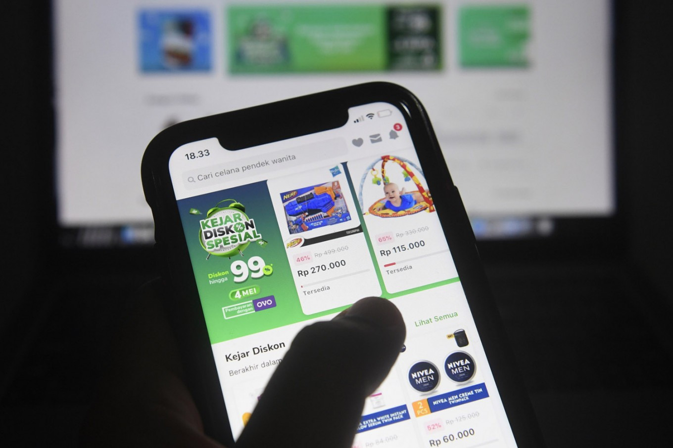 A customer shops on the Tokopedia online market place on his mobile phone on May 4.