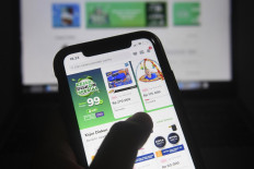 A customer shops on the Tokopedia online market place on his mobile phone on May 4.