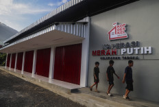 Three children walk past a Red and White Cooperative outlet on July 11, 2026, that has yet to begin operations in Ternate, North Maluku. The government aims to have 40,000 Red and White Cooperatives by the end of 2026 as part of efforts to strengthen rural economies, complete cooperative facilities and prepare professional staff to manage the program. 