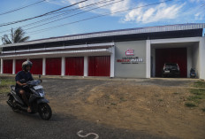 A motorcyclist rides past a Red and White Cooperative outlet that has yet to begin operations in Ternate, North Maluku, on July 11, 2026. The Indonesian government aims to have 40,000 Red and White Cooperatives by the end of 2026 as part of efforts to strengthen rural economies, complete cooperative facilities and prepare professional staff to manage the program. 
