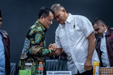 Acting Deputy Attorney General for Special Crimes Rudi Margono (left) shakes hands with National Police Anti-Corruption Corps chief Insp. Gen. Totok Suharyanto after a news conference at the Attorney General's Office in Jakarta on July 11, 2026. 