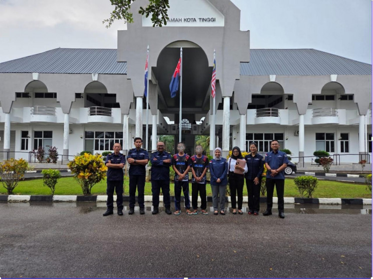 Two Indonesian fishing vessels skippers (fourth left and center) are flanked by Malaysian officers (left) and diplomats from the Indonesian Consulate General in Johor Bahru on July 6, 2026, in front of the Kota Tinggi Magistrate Court in Kota Tinggi, Johor. The court seized KM Hai Yang 3 and KM Baruna Jaya and imposed a fine of 10,000 ringgit (US$2,457) to each of the skippers, or a five-month jail term, for trespassing Malaysian waters.  
