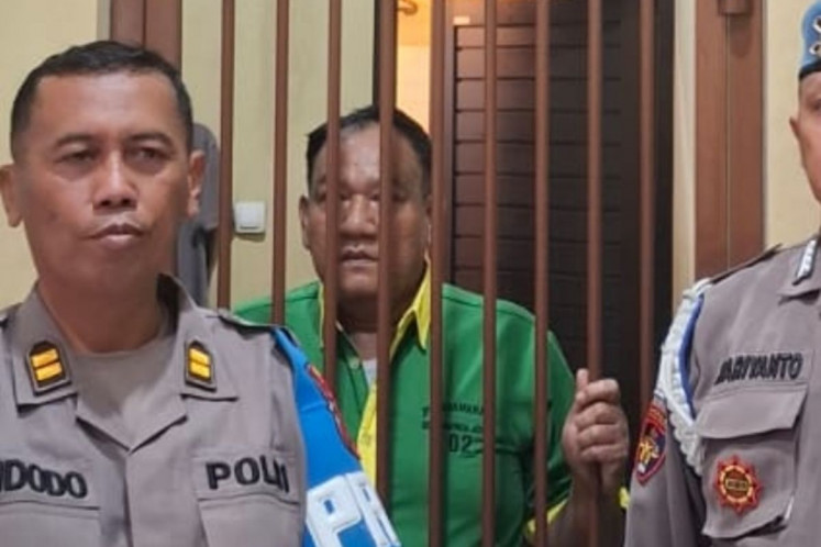 Nurudin (center), 50, who was dishonorably dismissed by the Central Java Police Professional Code of Ethics Committee on July 10, 2026, stands behind bars in the detention center at the provincial police headquarters in Semarang, in this undated handout photo.