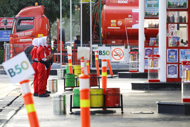 Workers stand at a petrol station for biodiesel containing 50 percent diesel fuel made of palm oil in Karawang, West Java, on July 9, 2026. 