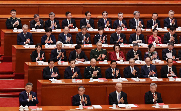 (front row, left to right) Chinese President Xi Jinping, Premier Li Qiang, Secretary of the Secretariat of the Chinese Communist Party Cai Qi, and Secretary of the Central Commission for Discipline Inspection of the Communist Party of China Li Xi applaud during the closing session of the National People's Congress (NPC) at the Great Hall of the People in Beijing on March 12, 2026. 