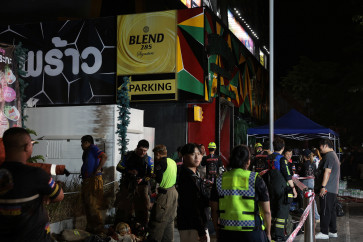 Members of emergency personnel work at the site of a deadly fire at a pub in Bangkok, Thailand, July 13, 2026.