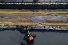 An aerial view shows heavy equipment reinforcing and raising the Lapindo mudflow embankment in Siring subdistrict, Porong district, Sidoarjo regency, East Java, on July 10, 2026. The work is intended to strengthen the embankment after a leak developed due to land subsidence and increased pressure from mud in the containment pond.