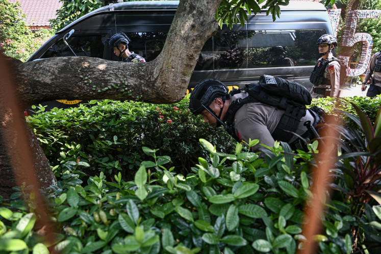 Officers from the Jakarta Police's Gegana bomb disposal unit search  SD Srengseng Sawah 15 Pagi state elementary school in Jagakarsa, South Jakarta, on July 13, 2026 after the school received a bomb threat via a messaging application. Authorities swept the campus to ensure it was safe before declaring the threat a hoax. 