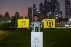 Thailand's Fifa Laopakdee poses with the Asia-Pacific Amateur Championship trophy and the flags representing his exemptions to the Masters and the 154th Open Championship on Oct. 26, 2025, after winning the Asia-Pacific Amateur Championship in Dubai, the United Arab Emirates.