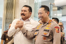 National Police chief Gen. Listyo Sigit Prabowo (right) and Attorney General ST Burhanuddin exchange a salute after meeting on July 13 at the Attorney General's Office in Jakarta. The two pledged to strengthen cooperation between their institutions amid public scrutiny over overlapping high-profile corruption investigations. 